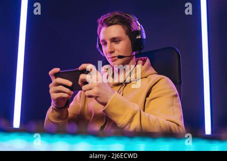 Pro cyber sportsman playing in mobile video game at home Stock Photo