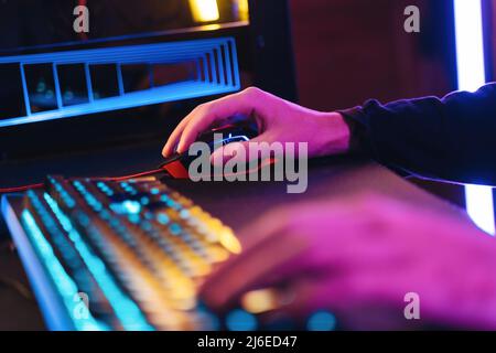 Close up of man gamer's hands using professional computer mouse and keyboard for playing video game Stock Photo