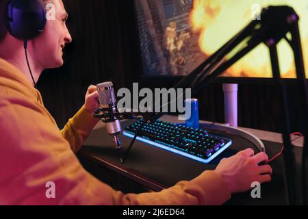 Young guy professional cyber sportsman streaming live video from online tournament Stock Photo