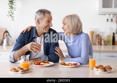 Happy elderly man and woman having lunch at home Stock Photo