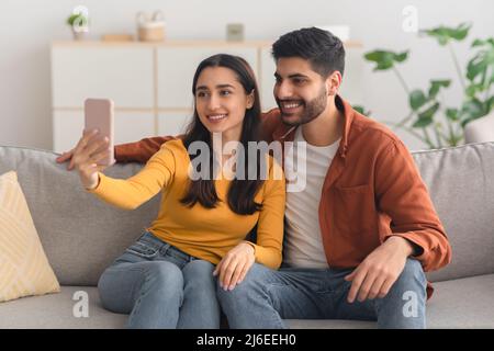 Happy Arabic Spouses Making Selfie Using Mobile Phone Indoor Stock Photo