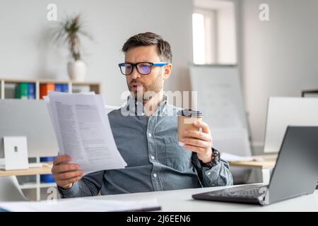 Concentrated middle aged businessman analyst manager working with documents and papers at workplace in office Stock Photo
