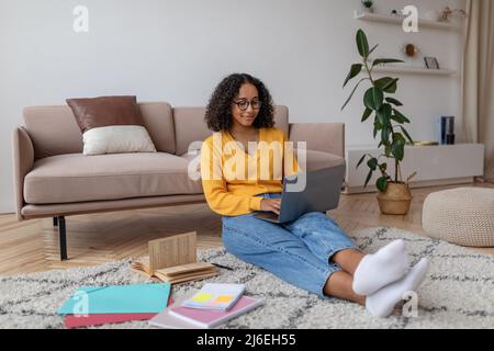 E-learning concept. Happy African American woman studying online on laptop computer at home, copy space Stock Photo