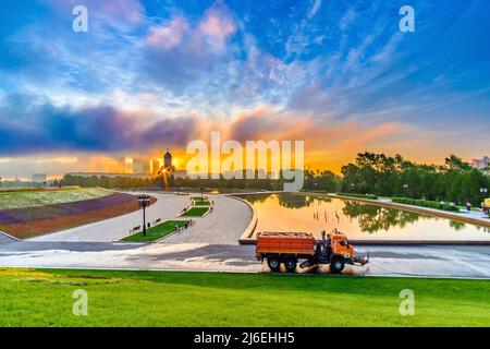 Moscow, Russia. July 05, 2020. Dawn over Victory Park on Poklonnaya Hill in Moscow in the summer. Colorful blue sky with clouds and sunrise on the horizon. A utility service machine in the foreground. Stock Photo