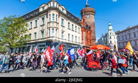 01 May 2022, Brandenburg, Cottbus: Participants of a demonstration march on the occasion of May Day through downtown Cottbus past the Spremberg Tower. DGB and the alliance #Unteilbar Südbrandenburg call for a joint rally under the motto 'GeMAInsam Zukunft gestalten' on the occasion of Labor Day 2022. Photo: Frank Hammerschmidt/dpa Stock Photo