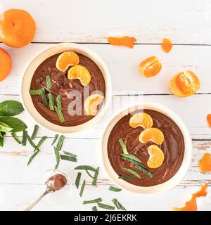 Chocolate cream in bowls with oranges and mint leaves Stock Photo