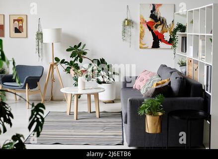 Image of modern living room with sofa and coffee table and green plants decorating the room Stock Photo