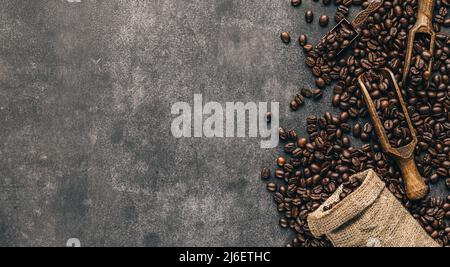 Abstract coffee background with copy space. Overturned bag full of roasted beans and spatula Stock Photo