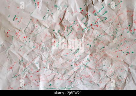 Crumpeled paper bacckground with paint splatters Stock Photo