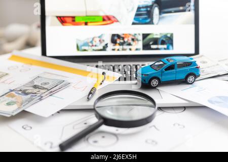 blue toy car with money and car key on wooden table. Stock Photo
