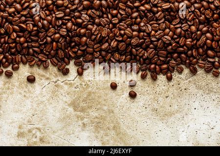 Roasted coffee beans over scratched stone wall texture. Top view on background copy space Stock Photo