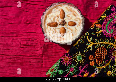 Sweet vermicelli dish called Seviyan ki kheer or Sheer khurma popular Indian and Pakistani. Sevaiyaan kheer garnished with almonds on bright multicolo Stock Photo