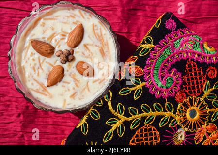 Sweet vermicelli dish called Seviyan ki kheer or Sheer khurma popular Indian and Pakistani. Sevaiyaan kheer garnished with almonds on bright multicolo Stock Photo