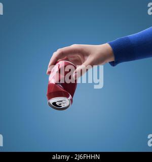 Hand holding a crushed can, separate waste collection and recycling concept Stock Photo