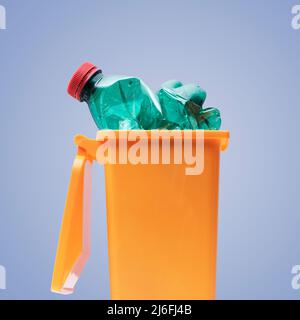 Plastic bottle in a small garbage can, recycling and separate waste collection concept Stock Photo