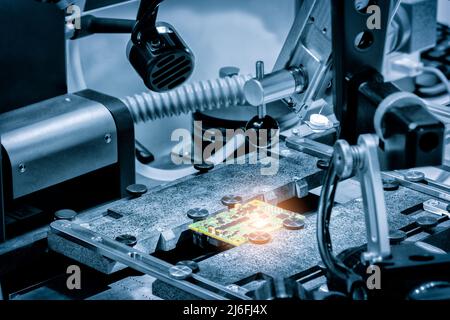 Chip testing equipment. Manufacturing of microchips. A close-up study of a test sample of a transistor chip under a microscope in the laboratory. Auto Stock Photo