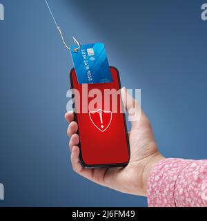 Phishing and cyber security: hacker stealing a user's credit card information on a smartphone Stock Photo