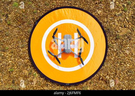 Drone above the runway before flying in an upper zenith shot. Stock Photo