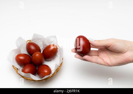 female hand holds a boiled red-dyed chicken egg. High quality photo Stock Photo