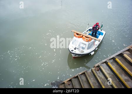 Looking down as on a small passenger ferry crossing the estuary at Barmouth arriving at the harbour steps Stock Photo