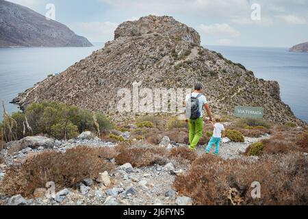 Father and son hiking in mountains on coast on a cloudy day Stock Photo