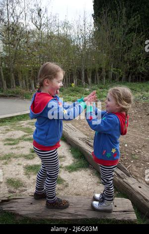 Kids playing Pat a Cake game, UK Stock Photo