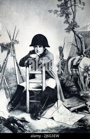 Illustration of Napoleon Bonaparte sitting in camp at Austerlitz (1805). An Imperial Guardsman stands sentry in the background. From a postcard c. early 1900s Stock Photo