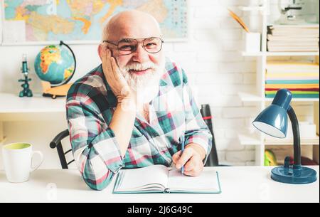Homeschooling with grandfather. Teacher is a rage of fun. Lesson is finished. Senior pedagogue study. Stock Photo