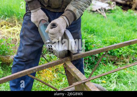 Close-up on the sides fly bright sparks from the angle grinder metal sawing Stock Photo