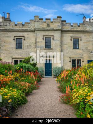 Beautiful Flowerbeds Lining The Approach To A Grand Old English Stately Home Or Mansion Stock Photo