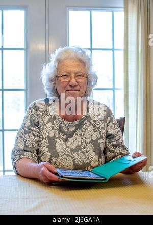 Happy older senior woman stays in touch with family and herr tablet, during covid lock down Stock Photo