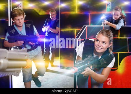 Excited children and theirs parents aiming laser guns at other p Stock Photo