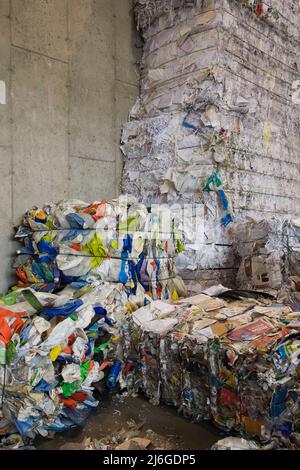 Bales of recyclable plastic containers and paper at sorting centre. Stock Photo