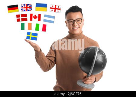 Portrait of Asian teacher with globe and different flags on white background Stock Photo