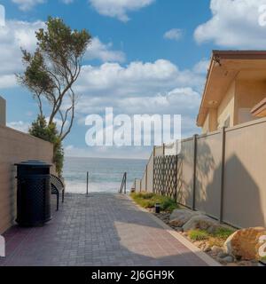 Square White puffy clouds Bricks pathway heading to the stairs of the beach at Carlsbad, C Stock Photo