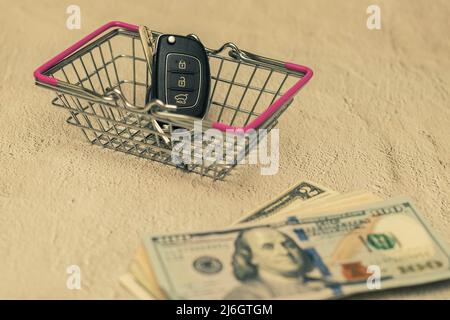 Car keys in a small shopping cart. The concept of buying a car Stock Photo