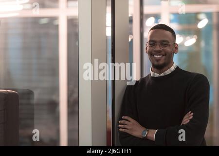African American man looking at camera standing in office lobby hall. Multicultural company managers team portrait. Stock Photo