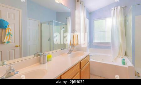 Panorama Sun flare Bathroom with light blue walls and windows at the corner with curtains Stock Photo