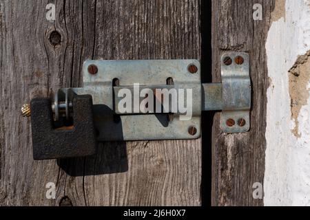 Old padlock, latch on wooden door with cracked texture. Close-up. High quality photo Stock Photo