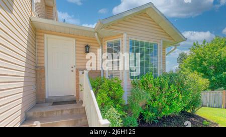 Panorama White puffy clouds White front door near the vinyl wood siding of a house in Utah Stock Photo