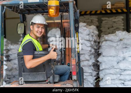 A Worker driving a forklift in alum or chemical warehouse. Stock Photo