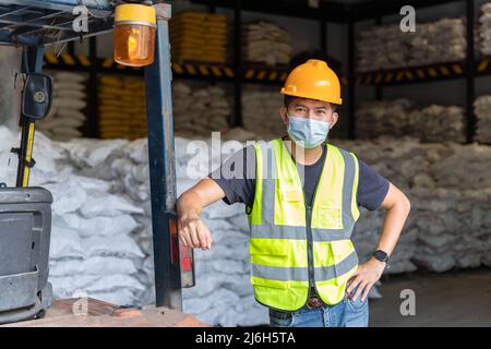 Forklift workers wear protective masks in chemical warehouse. Stock Photo