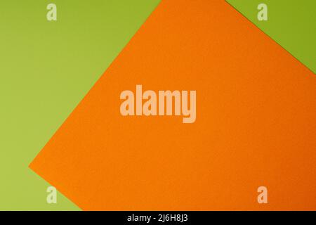 Orange and green colored background of layered cardboard sheets, top view, copy space Stock Photo