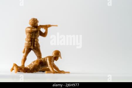 Selected focus crawling comando with out of focus soldier behind  toy soldiers Stock Photo