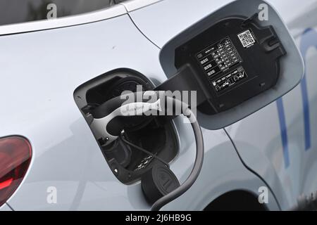 E-car is loaded, plug during the charging process on an e-car, electric car, charging plug, charging cable, charging column, charging socket, e-mobility, electrification. Electromobility, plug. Automaker,car,cars,automobiles,manufacturers,auto industry,electric vehicle,electric vehicles.Charging station. Stock Photo