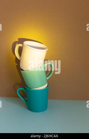 Three cups on blue table. brown wall background Stock Photo