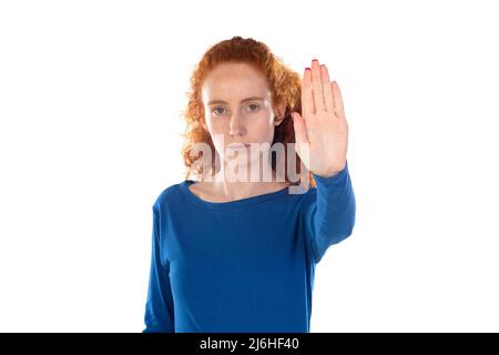 Redhead young woman wearing casual blue t shirt doing stop sing with palm of the hand. Warning expression with negative and serious gesture on the fac Stock Photo