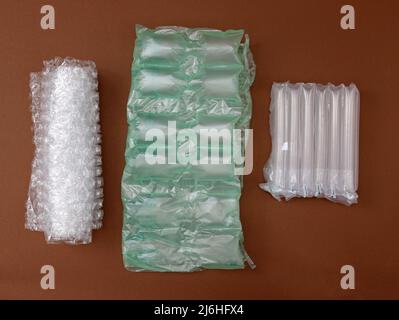 https://l450v.alamy.com/450v/2j6hfx4/a-pimply-bag-and-air-cushions-for-packing-fragile-parcels-on-a-brown-background-various-types-of-polypropylene-packaging-bags-bubble-wrap-and-perfo-2j6hfx4.jpg