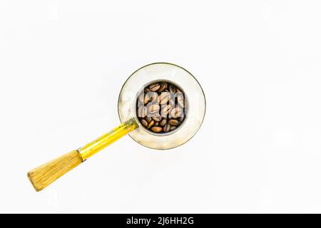 Close up macro image of Fresh coffee beans in round vintage coffee pot isolated in white background Stock Photo