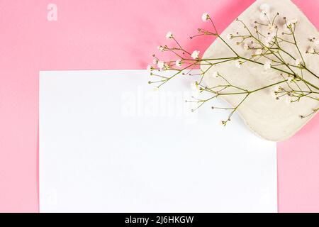 White blank notebook page with copy space for text with little flowers on pastel pink background top view. Empty wedding paper mockup, romantic Valent Stock Photo